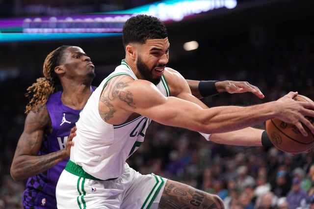 Mar 24, 2025; Sacramento, California, USA; Boston Celtics forward Jayson Tatum (0) holds onto a rebound in front of Sacramento Kings guard Keon Ellis (23) in the third quarter at the Golden 1 Center. Mandatory Credit: Cary Edmondson-Imagn Images