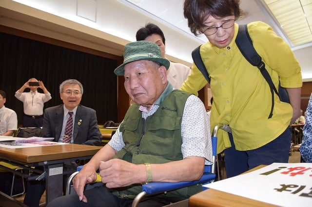 This photo taken on September 29, 2024 shows Iwao Hakamada (C) entering the venue during a judgement report session held by supporters in the city of Shizuoka, Shizuoka prefecture, two days after he was acquitted, more than half a century after his murder conviction, when a Japanese court ruled that evidence had been fabricated. Hakamada, now 88 years old, spent 46 years on death row after being convicted in 1968 of robbing and killing his boss, the man's wife and their two teenage children.