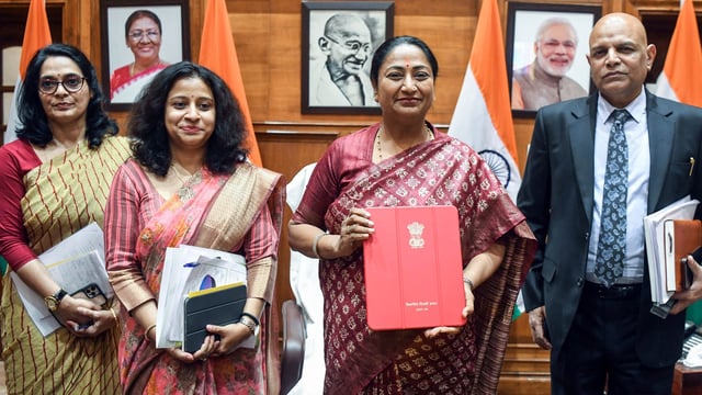 Delhi Chief Minister and Finance Minister Rekha Gupta holding the Budget Document along with her finance team members at her office.