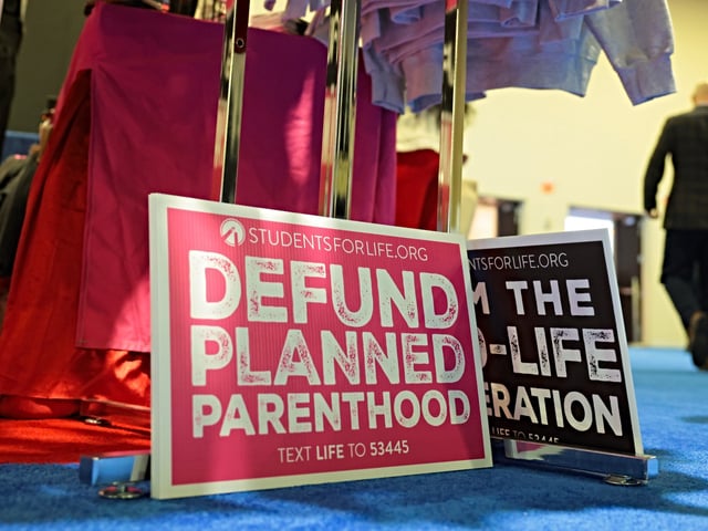 OXON HILL, MARYLAND - FEBRUARY 21: "Defund Planned Parenthood" signs lay on the ground at a booth during the Conservative Political Action Conference (CPAC) at the Gaylord National Resort & Convention Center on February 21, 2025 in Oxon Hill, Maryland. The annual four-day gathering brings together conservative U.S. lawmakers, international leaders, media personalities and businessmen to discuss and champion conservative ideas. (Photo by Kayla Bartkowski/Getty Images)