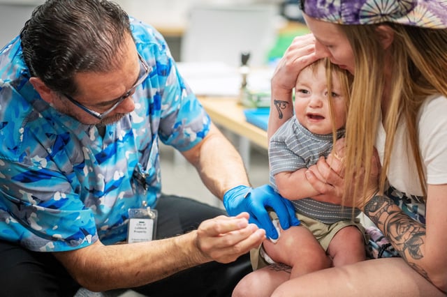 One year-old River Jacobs is held by his mother, Caitlin Fuller, while he receives an MMR vaccine at a vaccine clinic on March 1, 2025 in Lubbock, Texas. 