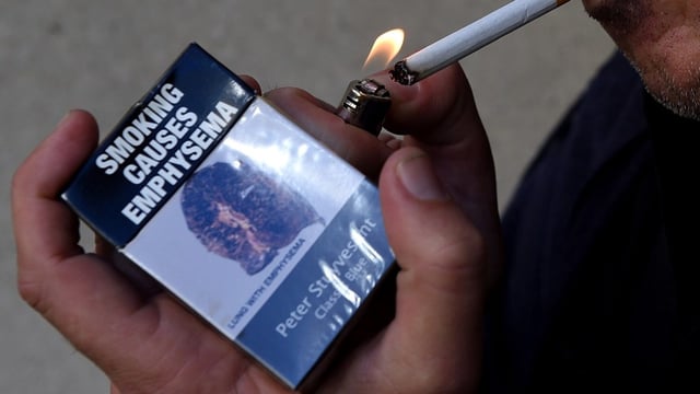 A man lighting a cigarette (Image: AAP/Sam Mooy)