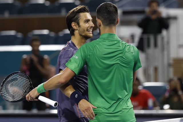 Mar 25, 2025; Miami, FL, USA; Novak Djokovic (SRB)(R) hugs Lorenzo Musetti (ITA)(L) at the net after their match on day eight of the Miami Open at Hard Rock Stadium. Mandatory Credit: Geoff Burke-Imagn Images