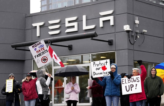 People attend a protest rally outside a Telsa dealership in Ottawa against CEO Elon Musk's political influence on Saturday, March 22, 2025. THE CANADIAN PRESS/Justin Tang