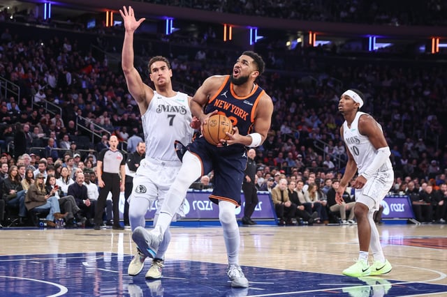 Mar 25, 2025; New York, New York, USA;  New York Knicks center Karl-Anthony Towns (32) drives past Dallas Mavericks center Dwight Powell (7) in the first quarter at Madison Square Garden. Mandatory Credit: Wendell Cruz-Imagn Images