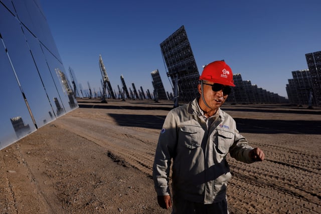 General manager of Dunhuang Shouhang Energy Saving New Energy Co. Liu Fuguo speaks to reporters next to heliostat mirrors, at the site of Shouhang 100MW Tower Solar Thermal Power Generation Project, during an organised media tour of Dunhuang Photovoltaic Industrial Park, in Gansu province, China October 16, 2024. REUTERS/Tingshu Wang/File Photo