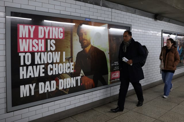 Commuters walk past past a campaign advertisement advocating for the legalisation of assisted dying at Westminster Station in London, Britain, November 28, 2024. REUTERS/Hollie Adams/File Photo