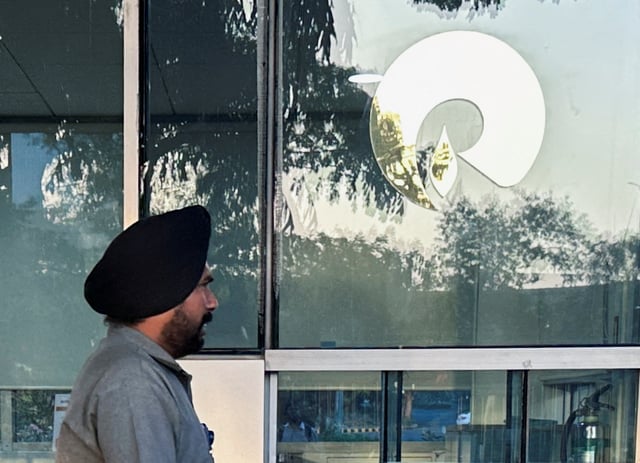 A guard walks past the Reliance Industries logo near the entrance of Dhirubhai Ambani Knowledge City in Navi Mumbai, March 15, 2024. REUTERS/Francis Mascarenhas/File Photo