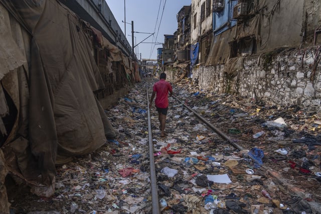 FILE - A man walks on a railway track littered with plastic and other waste materials on Earth Day in Mumbai, India, on April 22, 2024. (AP Photo/Rafiq Maqbool, File)