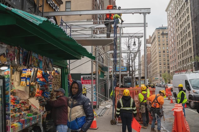 Workers put up a sidewalk shed in Manhattan on April 19, 2022.