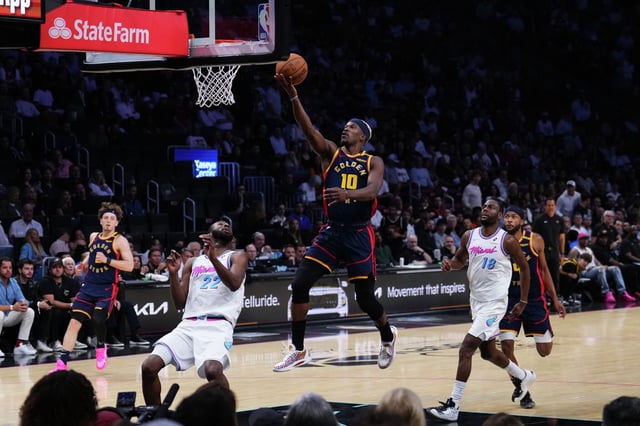 Jimmy Butler of the Golden State Warriors goes up for a shot against Andrew Wiggins of the Miami Heat during the third quarter of an NBA game at the Kaseya Center in Miami on March 25, 2025. 