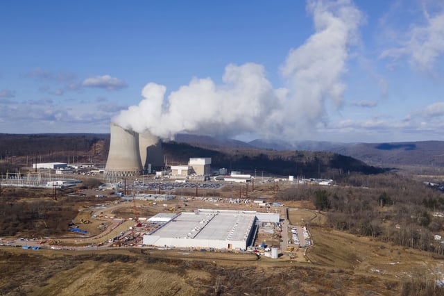 FILE - A data center owned by Amazon Web Services, front right, is under construction next to the Susquehanna nuclear power plant in Berwick, Pa., on Tuesday, Jan. 14, 2024. (AP Photo/Ted Shaffrey, File)