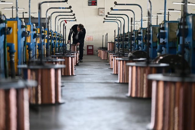 A worker produces copper-clad aluminum enamelled wire to supply overseas markets in a workshop at a factory in Suqian, Jiangsu province, March 6, 2025.
