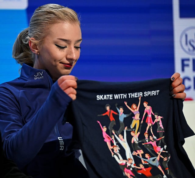 Amber Glenn holds up a t-shirt honoring the Washington D.C. plane crash victims during the ISU World Figure Skating Championships at TD Garden.