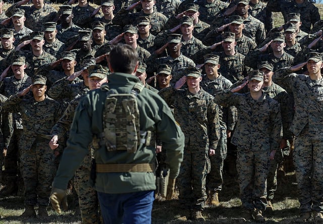 U.S. Marines can be seen saluting as Vice President JD Vance walks to greet them during a visit to Marine Corps Base Quantico on March 26, 2025, in Quantico, Virginia. (Photo by Kevin Dietsch/Getty Images)