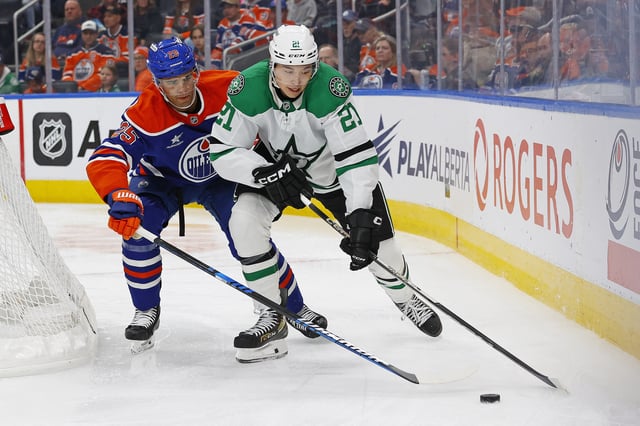 Mar 26, 2025; Edmonton, Alberta, CAN; Dallas Stars forward Jason Robertson (21) protects the puck from Edmonton Oilers defensemen Darnell Nurse (25) during the second period at Rogers Place. Mandatory Credit: Perry Nelson-Imagn Images