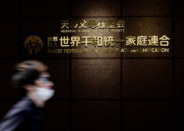 A person walks past the sign of Family Federation for World Peace and Unification, more commonly known as the Unification Church, at its Tokyo headquarters in Tokyo, Japan August 29, 2022. REUTERS/Kim Kyung-Hoon/File photo