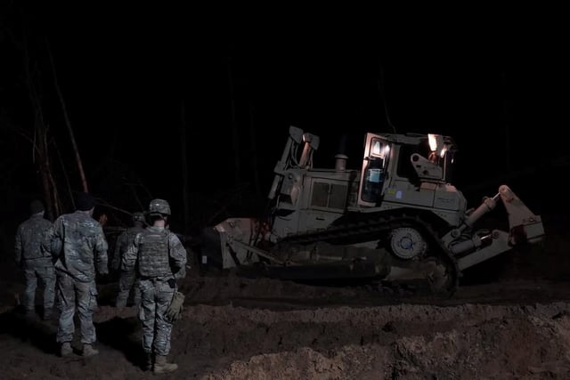 Digger and soldiers at scene of rescue operation at Pabrade training ground, March 26, 2025. LITHUANIAN DEFENCE MINISTRY/Handout via REUTERS