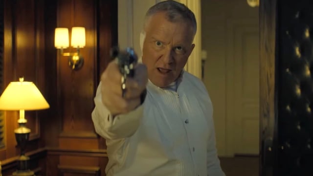 Zachary Beck holding a gun in Reacher Season 3.