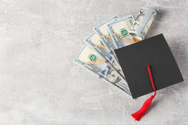 Stock image/file photo: A mortarboard with U.S. Dollar bills.