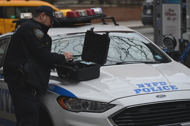 An NYPD officer handles evidence at a crime scene in Manhattan on March 17, 2025.