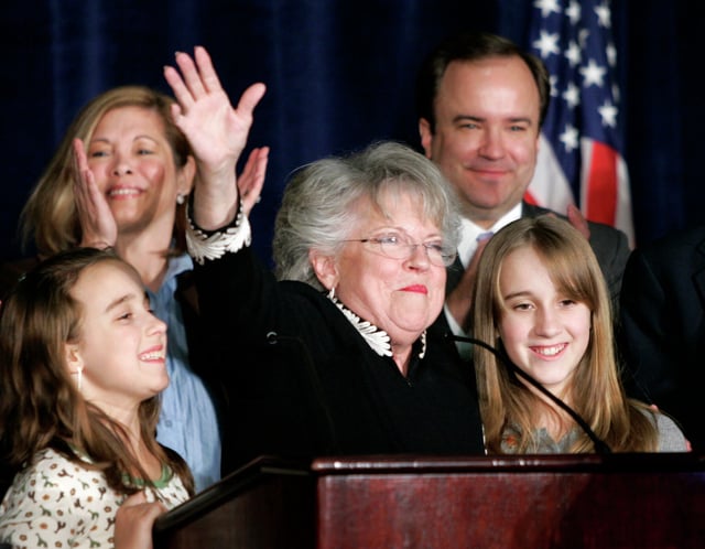 In this file photo gubernatorial candidate Carole Keeton Strayhorn, center in glasses, waves to supporters in an audience where she made her concession speech surrounded by members of her family, Michelle McClellan, left front, Kathryn McClellan, right front, Scott McClellan, right rear, and his wife Jill, left rear, in Austin, Texas, Tuesday, Nov. 7, 2006. (AP Photo/Tony Gutierrez)