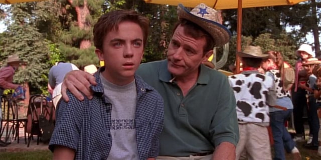 Bryan Cranston sitting in a child's cowboy hat with his arm around Frankie Muniz in an episode of Malcolm in the Middle