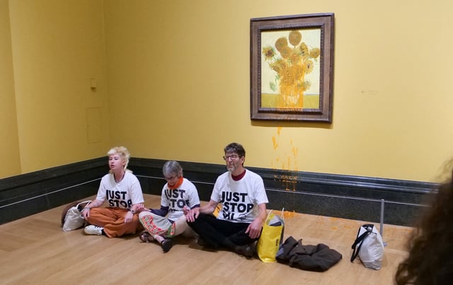 Trois activistes de Just Stop Oil assis par terre sous les « Tournesols » de Vincent van Gogh après avoir jeté de la soupe à la National Gallery dans le centre de Londres, le 27 septembre 2024.