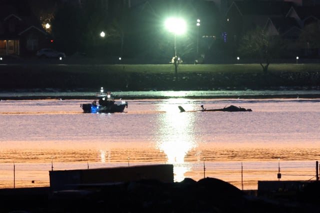 Rescuers on a boat work next to the wreckage of a Black Hawk helicopter, as the sun rises, at the site of the crash after it collided with the American Eagle flight 5342, which was approaching Reagan Washington National Airport, and crashed into the Potomac River, outside Washington, U.S., January 30, 2025. REUTERS/Kevin Lamarque/File Photo