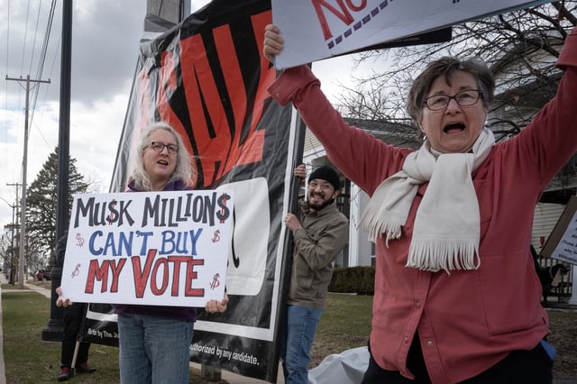 Demonstrators protest outside of an event hosted by Circuit Court Judge Brad Schimel, a candidate for the Wisconsin Supreme Court. Schimel, who has been endorsed by President Donald Trump and financially supported by billionaire businessman Elon Musk, is running against Dane County Circuit Court Judge Susan Crawford.