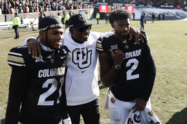 Shilo Sanders #21, Head coach Deion Sanders and Shedeur Sanders #2 of the Colorado Buffaloes pose for a photo after the game against the Oklahoma State Cowboys at Folsom Field on November 29, 2024.