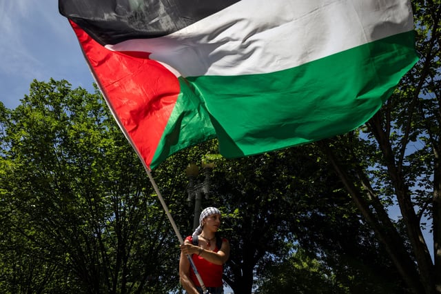A pro-Palestinian activist waves a large Palestinian flag on Pennsylvania Avenue in front of the White House during a demonstration protesting the war in Gaza on June 8, 2024 in Washington, DC. (Photo by Samuel Corum/Getty Images)