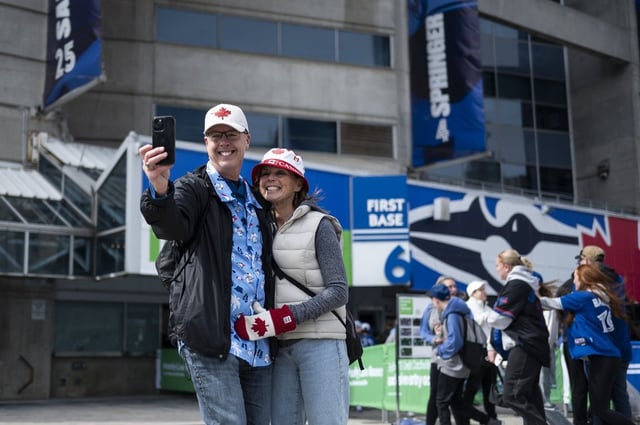 Fred Masters and Kathy Doherty-Masters from Kitchener, Ont., take a selfie ahead of the Toronto Blue Jays home opener against the Baltimore Orioles, in Toronto on Thursday, March 27, 2025. THE CANADIAN PRESS/Christopher Katsarov
