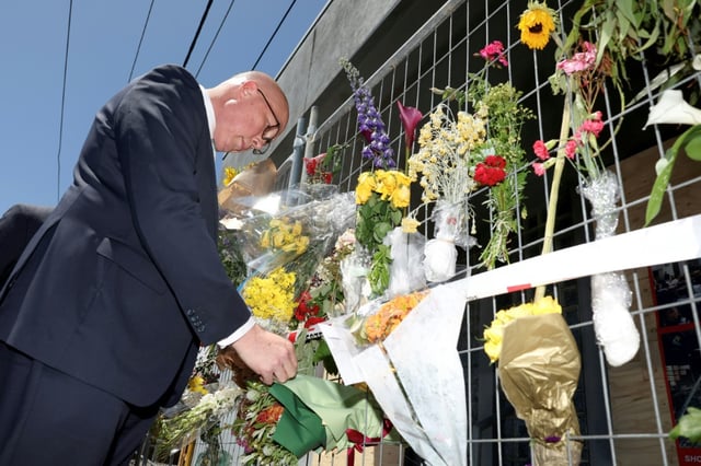 Dutton looks at floral tributes placed outside the firebombed Adass Israel Synagogue in Melbourne