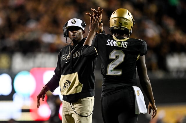 Head coach Deion Sanders of the Colorado Buffaloes celebrates with quarterback Shedeur Sanders #2 after a fourth quarter touchdown against the Colorado State Rams at Folsom Field on September 16, 2023.