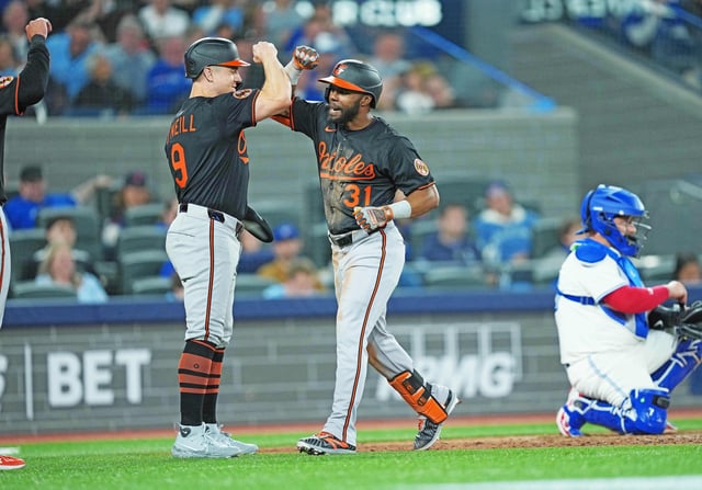 Mar 27, 2025; Toronto, Ontario, CAN; Baltimore Orioles centre fielder Cedric Mullins (31) hits a home run and celebrates with Baltimore Orioles centre fielder Tyler O'Neill (9) against the Toronto Blue Jays during the seventh inning at Rogers Centre. Mandatory Credit: Nick Turchiaro-Imagn Images