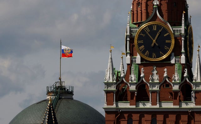 The Russian flag flies on the dome of the Kremlin Senate building behind Spasskaya Tower, while the roof shows what appears to be marks from the recent drone incident, in central Moscow, Russia on May 4, 2023.