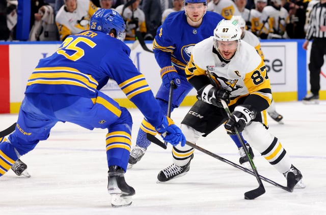 Mar 27, 2025; Buffalo, New York, USA;  Buffalo Sabres defenseman Owen Power (25) defends as Pittsburgh Penguins center Sidney Crosby (87) skates with the puck during the first period at KeyBank Center. Mandatory Credit: Timothy T. Ludwig-Imagn Images
