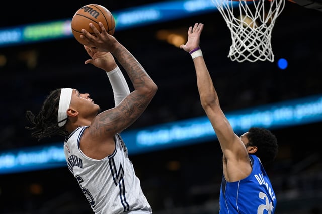 Orlando Magic forward Paolo Banchero (5) goes up to shoot as Dallas Mavericks guard Spencer Dinwiddie, right, defends during the first half of an NBA basketball game, Thursday, March 27, 2025, in Orlando, Fla. (AP Photo/Phelan M. Ebenhack)