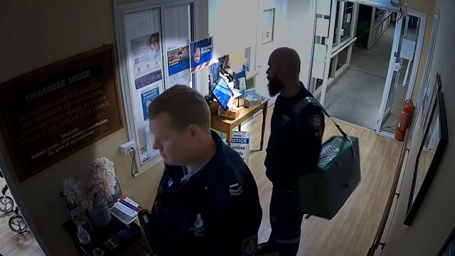 This screengrab from a security camera shows Senior Constable Kristian White approaching the room where Nowland sat with her mobility walker.
