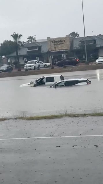 Vehicles are partially submerged in flood waters at a road in McAllen, Texas, on March 27, 2025 in this screengrab obtained from a social media video.
