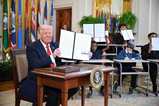 President Donald Trump holds an executive order to start dismantling the Department of Education on March 20, 2025.
