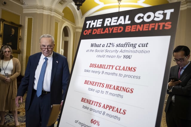 Senate Minority Leader Chuck Schumer (D-N.Y.) stands near a sign about the effects of proposed staffing cuts at the Social Security Administration as during a press conference at the U.S. Capitol March 25, 2025.