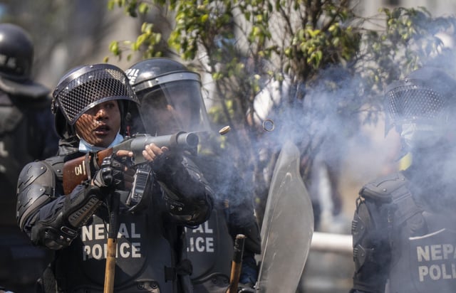A policeman fires a tear gas shell during a protest in Kathmandu, Nepal, on Friday, March 28, 2025. (AP Photo/Niranjan Shrestha)
