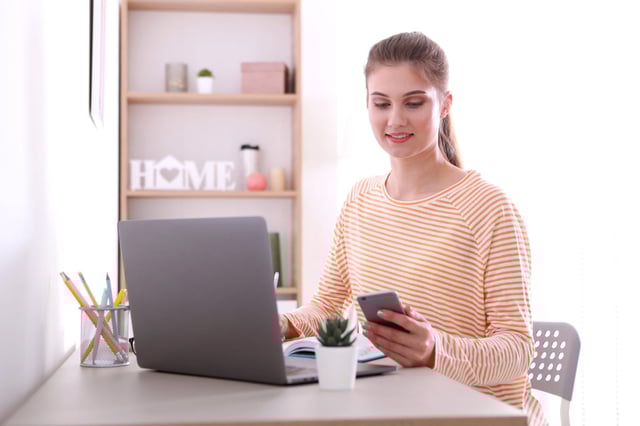 The girl works remotely from home using a modern laptop