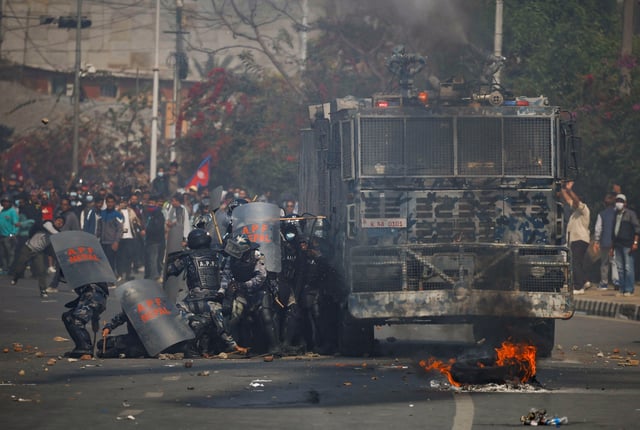 Riot police personnel take cover from stones hurled by pro-monarchist demonstrators during a protest demanding the restoration of Nepal's monarchy, which was abolished in 2008, saying the governments have failed to make any significant changes, in Kathmandu, Nepal, March 28, 2025. REUTERS/Navesh Chitrakar