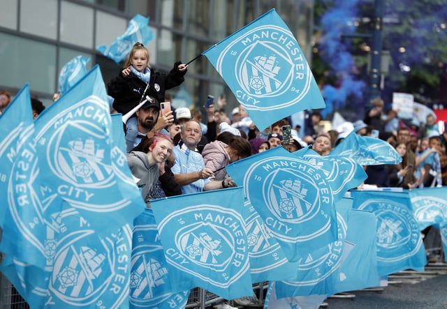 Soccer Football - Premier League - Manchester City Victory Parade - Manchester, Britain - May 26, 2024 Manchester City fans with flags during the victory parade Action Images via Reuters/Jason Cairnduff/File Photo