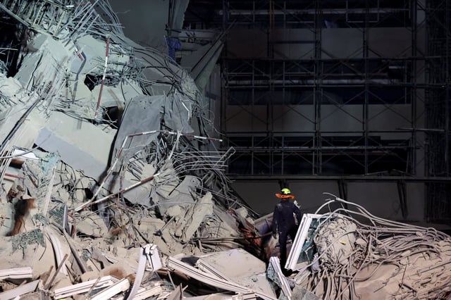 A rescue personnel searches for casualties at the site of a building that collapsed after a strong earthquake struck central Myanmar on Friday, earthquake monitoring services said, which affected Bangkok as well with people pouring out of buildings in the Thai capital in panic after the tremors, in Bangkok, Thailand, March 28, 2025. REUTERS/Athit Perawongmetha