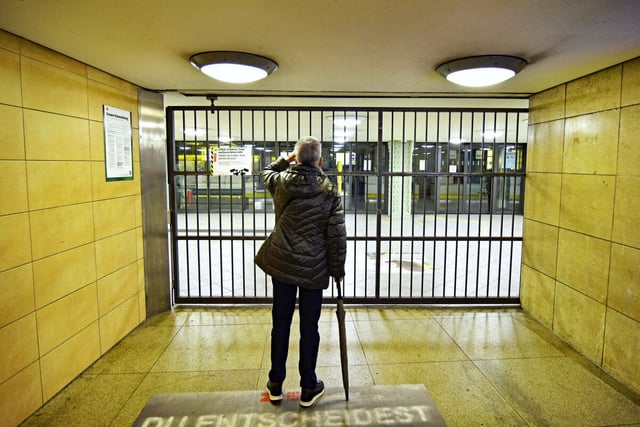Eine Person steht vor einer vergitterten U-Bahn-Station