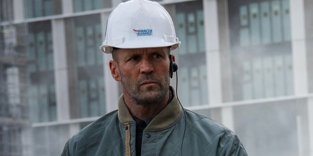 Jason Statham as Levon Cade at a construction site wearing a hard hat in A Working Man.